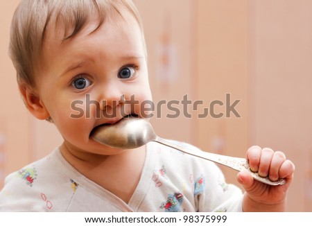 Portrait of baby girl holding spoon in mouth