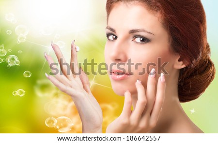Beauty Girl Portrait. Beautiful Spa Woman Touching her Face.Natural Cream for Skin Face
