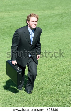 business man marches up the green grass to make the sale