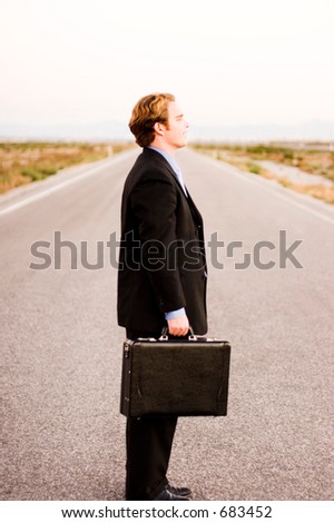 Businessman stands in the middle of the road, niether coming or going