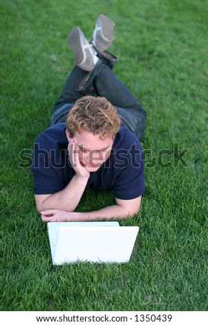 College Student outside in the park using his laptop