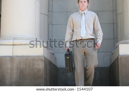 Lawyer is walking down the steps of the courthouse towards you with a black briefcase in his hand