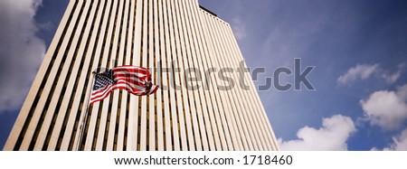 Business Building reaching to the sky with an American flag in front of it waving