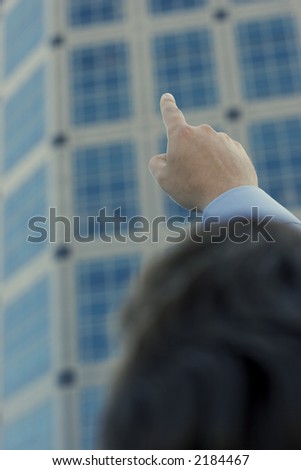 Businessman raising and pointing his finger towards the sky as a new standard