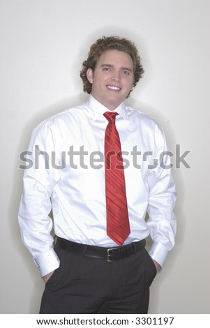 Young businessman standing with confidence with a white button down shirt and a red tie with a big toothy smile