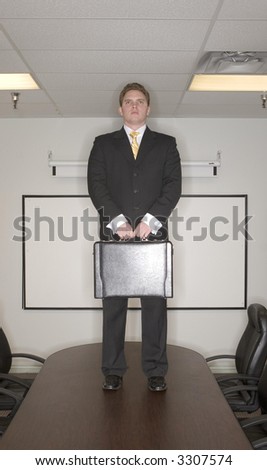 Businessman stands on top of a conference table in the boardroom in success