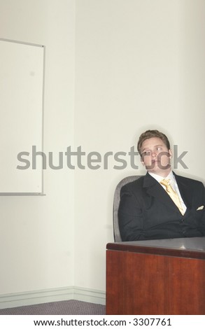 Businessman looking over while sitting in his chair at his desk in the office