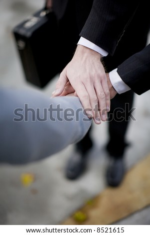 close-up of three business men\'s hands on top of each other