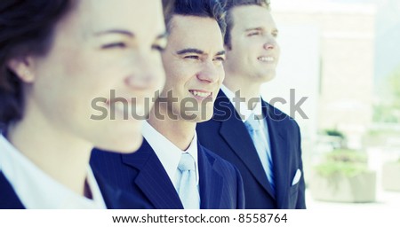 three business people standing in a row looking in same direction