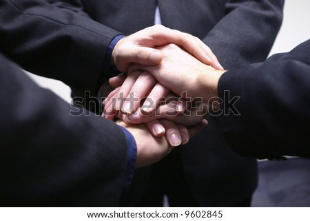 close-up of three businessmen hands on top of each other