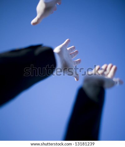 three open hands and arms with blue sky in background
