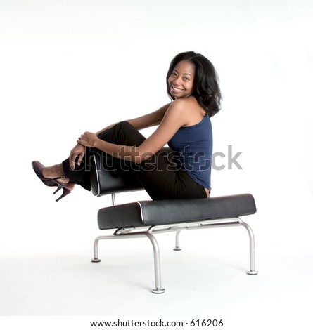 Happy African American woman with her legs over the back of a chair