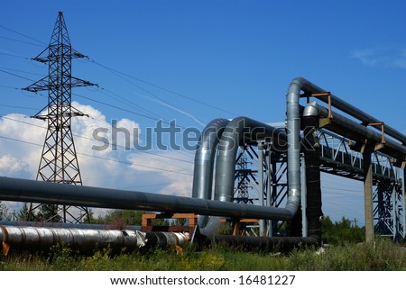 industrial pipelines on pipe-bridge and electric power lines against blue sky