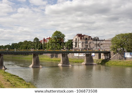 UZHHOROD, UKRAINE - MAY 18: Pedestrians walk around bridge over Uzh River connecting old and modern town on May 18, 2012 in Uzhhorod, Ukraine. The city gets its name from the Uzh River.