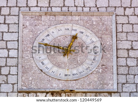 stony clock first mentioned in 1538 on townhall in city Krk with golden hands and roman clock dial. Croatia