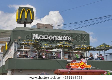 KIEV, UKRAINE - July 05:  Visitors eat in the open air under the sun umbrellas in McDonald\'s fast food restaurants in front of Kiev Central Passenger Railway Station on July 05, 2013 in Kiev, Ukraine.