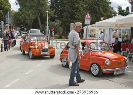 NOVIGRAD, CROATIA - SEPTEMBER 13, 2014: Unrecognizable people watch the parade of vintage cars on 5th International Old Timer Car Rally organized by the old timer club Eppur si muove from Umag.