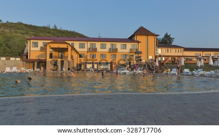 BEREHOVE, UKRAINE - SEPTEMBER 02,2015: Unrecognizable people swim in outdoor thermal spa pool Zhayvoronok. Berehove city became famous for its unique thermal healing waters of high salinity.