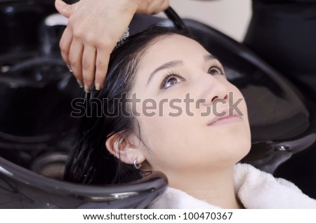 Young woman getting her hair washed in a hair salon
