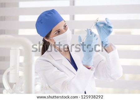 Hispanic female dentist preparing a shot of anesthesia