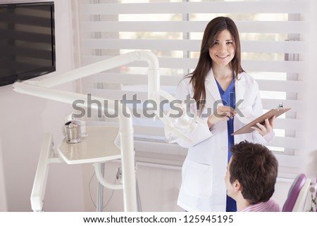 Beautiful latin dentist reviewing patient records