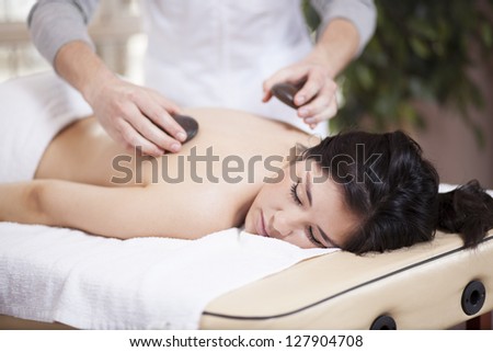 Very relaxed latin woman getting a stone massage at a spa