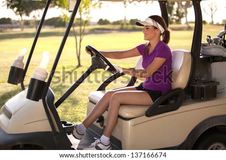 Cute Latin female golfer driving to the next hole in a golf course