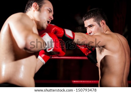 Stronger boxer punching his opponent during a fight