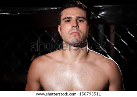 Latin MMA Fighter in a fighting cage with some copy space