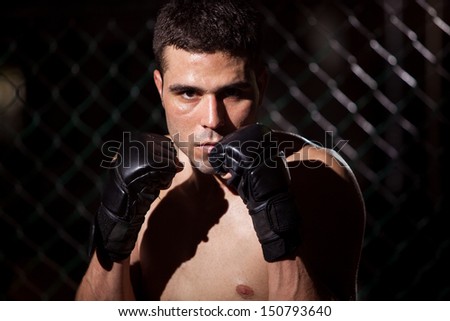 Latin mixed martial arts fighter waiting for his next opponent in a fighting cage