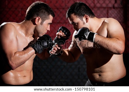Young Hispanic mixed martial arts fighters during a fight in a cage