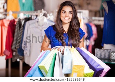 Pretty girl carrying a lot of shopping bags after shopping in a clothing store