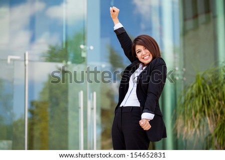 Happy female business school student raising her arms and celebrating her success
