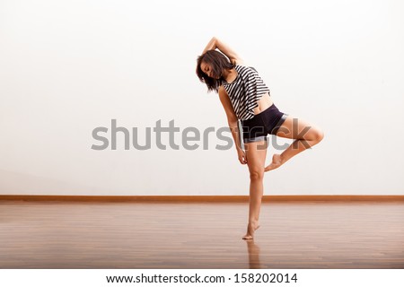 Sexy female Latin jazz dancer trying out some dance moves in a dance studio