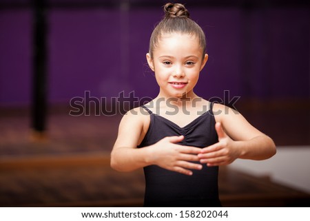 Portrait of a cute little girl practicing a dance pose in a dance academy