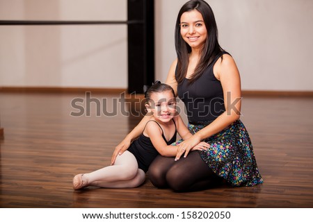 Cute female dance instructor and a student having fun and smiling during dance class