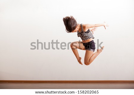 Female jazz dancer in the middle of a jump as part of a dance routine