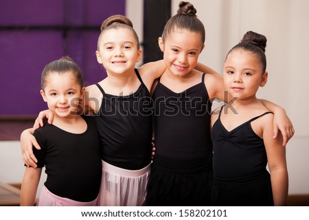 Pretty little girls having fun and hugging each other during a dance class