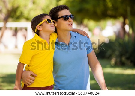 Portrait of both father and son wearing sunglasses and looking towards copy space