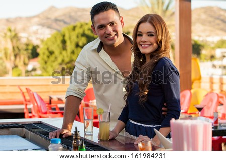 Portrait of a beautiful Latin couple drinking and flirting at a bar