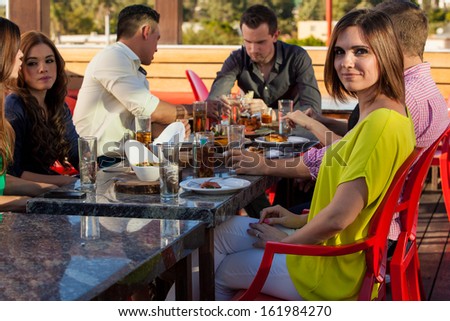 Young woman hanging out with some friends at a restaurant outdoors