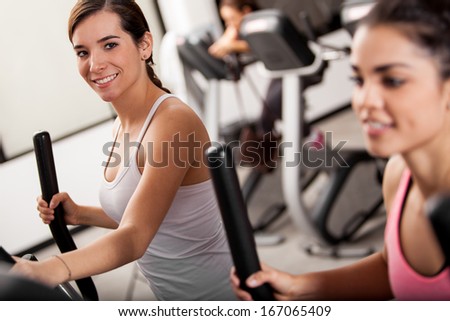 Cute young women taking a gym class in elliptical trainers