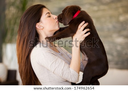 Cute young brunette getting some puppy love from her cute Labrador