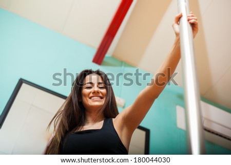 Beautiful young woman ready for her pole fitness class and smiling. Low angle of view