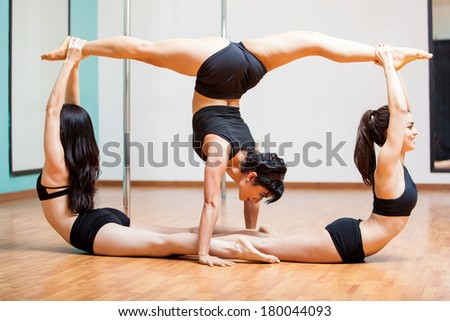 Beautiful pole dancers working together to show off their strength and flexibility