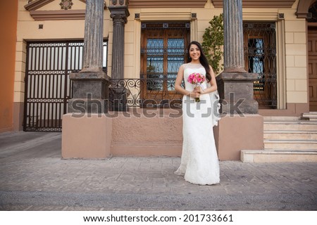 Full length portrait of a cute bride waiting outside a church on her wedding day
