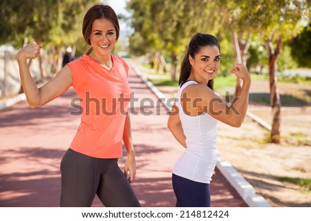 Pretty female runners having fun and showing off their muscles before going for a run
