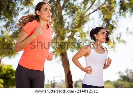 Beautiful Latin young women running and racing outdoors on a sunny day