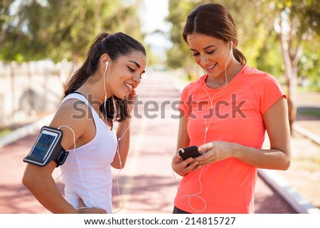 Cute female runners getting ready and sharing songs before going for a run