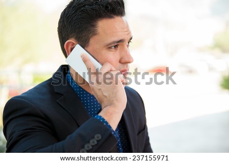 Closeup of an attractive young Hispanic businessman during a call with his mobile phone